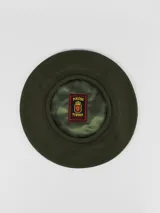 Boina de hilo color verde oliva con forro interior de satén y etiqueta de la marca Tolosa Tupida.