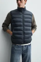 Chaleco acolchado de hombre color negro, con diseño puffer, cuello alto y cierre frontal con cremallera.