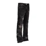 Jeans negros de corte flare con diseño de estrellas aplicadas en tono grisáceo y detalles desgastados con roturas en las piernas.