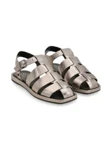 Sandalia plana tipo cangrejera de cuero color plomo metalizado, con tres tiras sobre el empeine y pulsera de ajuste con hebilla metálica.