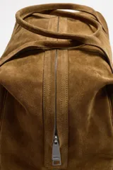 Bolso de mano marrón de cuero con acabado serraje. Tiene un compartimento principal con cierre de cremallera, dos bolsillos interiores (uno con cremallera) y asas de mano de cuero.