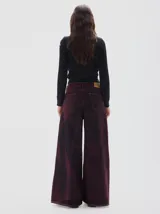 Jean wide leg de algodón con lavado washed bordó, cinco bolsillos y detalles en hilos dorados.