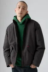 Campera puffer corta color gris oscuro, con cierre frontal y dos bolsillos con solapa y botón.