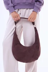 Cartera tipo hobo de diseño curvo, confeccionada en material símil gamuza con textura trenzada. Cuenta con una correa integrada al cuerpo del bolso y cierre superior.