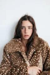 Cazadora de Zara con efecto pelo, diseño de cuello solapa y manga larga. Presenta un estampado animal print tipo cervatillo, bolsillos delanteros y cierre frontal con ganchos metálicos.