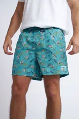 Short de baño con cintura elástica y cordón ajustable, confeccionado en tela ligera de secado rápido. Presenta un estampado botánico integral en tonos amarillos, blancos y azules, con dos bolsillos delanteros y uno posterior.