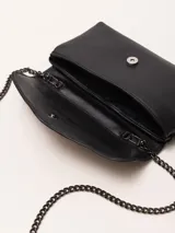 Cartera sobre negra de cuero vacuno graneado con solapa de pelo vacuno y aplique metálico con forma de labios. Tiene correa de cadena metálica desmontable con hombrera de cuero, forro de tejido jacquard y bolsillo interno.