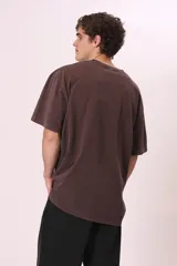 Camiseta de manga corta, color gris oscuro con efecto lavado, corte oversize y cuello redondo. Presenta un pequeño estampado en el pecho con el texto "CREW MEMBER" en blanco.