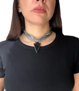 Gargantilla choker con múltiples cadenas plateadas y dije colgante en forma de flecha de piedra ágata negra.