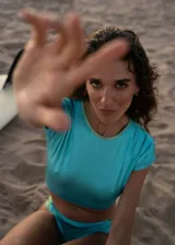 Top corto turquesa de lycra reciclada con cuello redondo y mangas cortas.