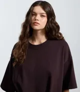 Remera oversize blanca de manga corta, con cuello redondo y diseño holgado, confeccionada en mezcla de algodón y poliéster.