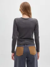 Remera de manga larga con cuello a la base, confeccionada en tejido acanalado con calce al cuerpo y diseño tipo crop.