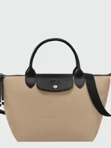 Cartera de mano Longchamp modelo Le Pliage Energy tamaño S, confeccionada en lona de color bordó con detalles en cuero negro. Cuenta con doble asa superior, correa de hombro ajustable y extraíble, cierre principal con cremallera y solapa frontal con broche a presión.