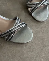 Sandalia de vestir color plateado con tiras cruzadas en el empeine y taco de 7 cm.