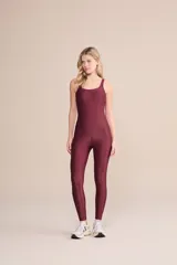 Jumpsuit largo de una pieza, color bordó, con diseño ajustado, escote redondo y tirantes anchos. Confeccionado en tejido con acabado satinado y elástico.