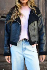 Campera de cuero sintético marrón con interior y detalles de corderito sintético blanco, cuello con solapas, cierre frontal y bolsillos con cremallera.