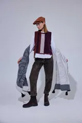 Chal de lana con diseño de patrón paisley y detalles de tejido en punto. Presenta terminaciones con pompones en los extremos.