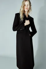 Abrigo largo entallado de Zara, confeccionado en mezcla de lana, con cuello solapa, manga larga, cierre frontal con botones, bolsillos con solapa y abertura en la espalda.