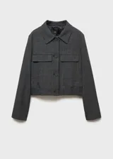 Chaqueta corta de tweed a cuadros grises, con cuello camisero, solapas decorativas, cierre frontal con botones y bajo con goma elástica.
