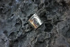 Anillo ancho de alpaca con textura irregular.