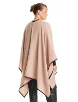 Ruana de tejido soft color beige, con escote en V, cierre frontal con botones metálicos y bordes ribeteados en cuero sintético negro.