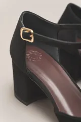 Sandalia de cuero color bordó, con acabado charolado, punta fina y tacón cuadrado de 5 cm. Presenta una tira en forma de T sobre el empeine y una correa con hebilla alrededor del tobillo.