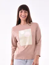 Remera de manga larga color beige con estampado frontal de un arcoíris dorado y círculos en tonos pastel.