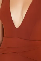 Malla enteriza color terracota con escote profundo en V, tirantes cruzados en la espalda y detalle de frunces cruzados en la cintura.