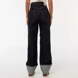 Jean de corte regular y tiro alto, confeccionado en denim azul oscuro. Presenta un diseño de pierna recta con un dobladillo ancho y llamativo en la parte inferior que deja ver el revés de la tela.
