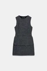 Vestido midi de cuello redondo y sin mangas, con diseño que simula un conjunto de dos piezas. Presenta cierre frontal con botones forrados y un cinturón integrado a tono que marca la cintura.