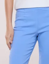 Pantalón capri estilo sastrero de tiro alto, color celeste, con cintura ancha elastizada sin cierres, bolsillos funcionales en el frente y bolsillos simulados en la parte posterior.