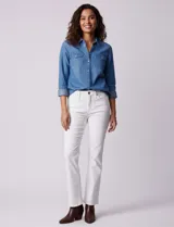 Camisa de manga larga en tela denim de color azul medio, con cuello clásico, botones frontales y dos bolsillos de parche con solapa en el pecho.