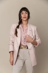 Blazer de cuero color lavanda, con cuello y solapa, bolsillo pequeño en el pecho y dos bolsillos con tapa en el frente.