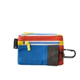 Billetera pequeña tipo pouch con múltiples compartimentos con cierre de cremallera en bloques de color: rojo, blanco, azul y gris oscuro. Incluye tiradores de cremallera amarillos y un mosquetón negro con cinta estampada con el logo de la marca.