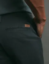 Pantalón de corte clásico confeccionado en sarga de algodón con elastano, color verde militar. Presenta bolsillos delanteros inclinados y bolsillos traseros de ribete.