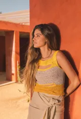 Top corto tejido de punto a crochet, sin mangas, con diseño multicolor en celeste, beige y azul, y aberturas frontales estratégicas tipo cut-out.