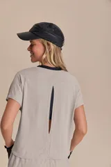 Remera deportiva verde militar de calce suelto, con mangas cortas, sisas desplazadas y abertura en la espalda. Confeccionada en tejido liviano y respirable con tecnología Quick Dry y Easy Care.