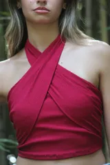 Top negro con diseño cruzado en el frente, estilo halter y con detalles de tachas doradas.