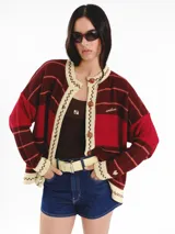 Cardigan tejido de punto jacquard en tonos bordó y rojo con rayas, de corte oversize, cuello redondo y cierre frontal con botones carey. Presenta detalles bordados en contraste y monograma en la espalda.