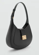 Bolso de hombro tipo hobo en color negro, con diseño curvo y cierre frontal mediante solapa con hebilla metálica dorada. Cuenta con un asa ajustable y forro interior con bolsillo con cremallera.