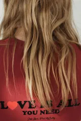 Camiseta de algodón de corte regular, con cuello redondo y manga corta. Presenta un estampado con texto a contraste en el frente y bajo recto.