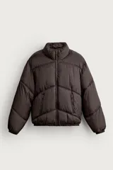 Cazadora acolchada de corte relajado color marrón oscuro, con cuello subido, cierre frontal de cremallera y bolsillos laterales con cierre. Presenta puños y ruedo con terminación elástica.