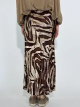 Pollera larga de tiro alto con estampado abstracto en tonos marrones y beige.