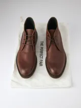 Botas de cuero marrón con cordones, caña baja y suela de goma.