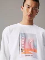 Remera blanca de manga larga con cuello redondo y estampado fotográfico digital de una cancha de baloncesto en el pecho.