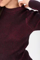 Sweater de punto acanalado negro con sutiles destellos cobrizos, de cuello redondo y manga larga.