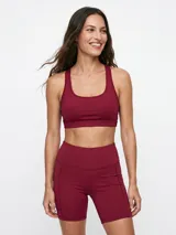 Top deportivo negro con diseño de espalda deportiva y escote redondo.