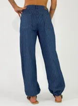 Pantalon de denim azul con diseño de rayas verticales blancas, de corte holgado y estilo relajado.