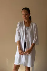 Bata tipo kimono de algodón blanco, con mangas al codo y largo por encima de la rodilla. Incluye lazo ajustable en la cintura.
