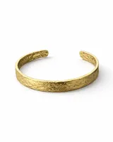 Pulsera rígida abierta (tipo brazalete) de metal dorado con acabado texturizado rugoso.